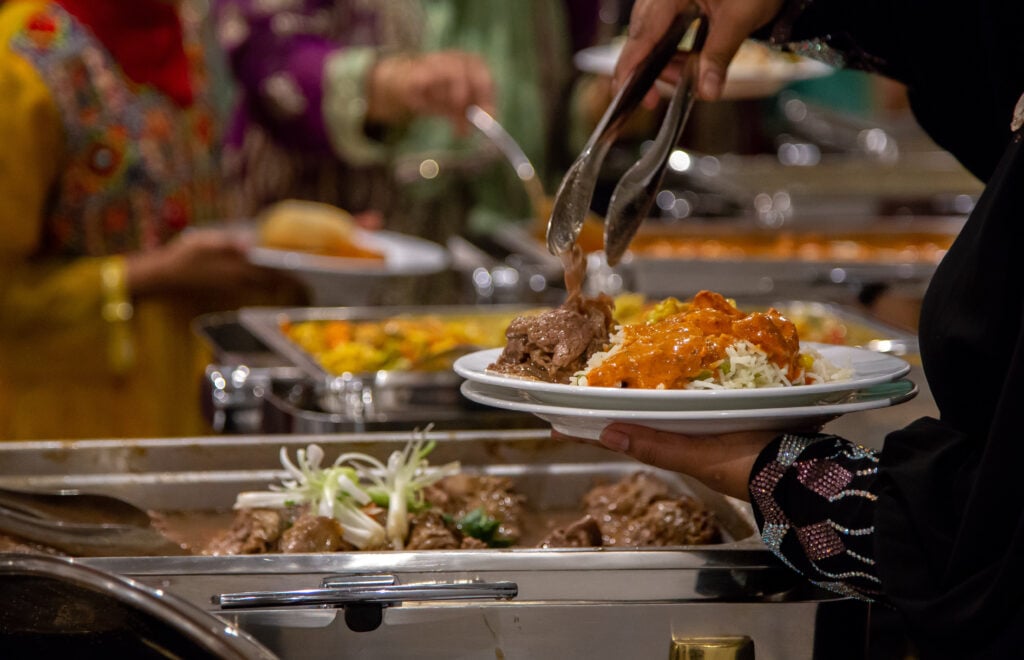 PeopleGrabbingFoodFromBuffetTableInTheBanquetHall - Iacofanos