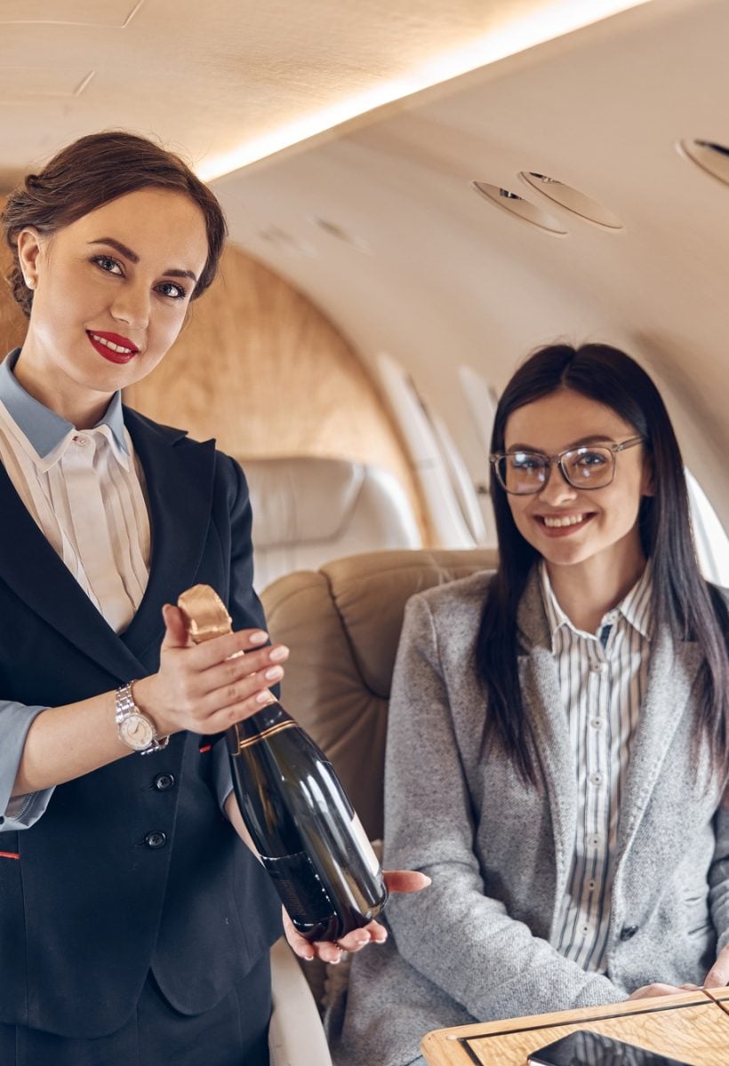 Happy smiling beautiful business woman in private jet
